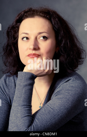 portrait of a pensive woman on a dark background Stock Photo