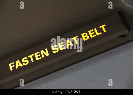 Aircraft cabin overhead illuminated sign, Fasten Seat Belt Stock Photo