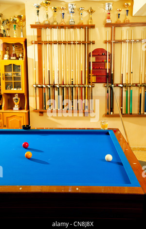 Billiard club with blue pool table cue in a row and winner trophy Stock Photo