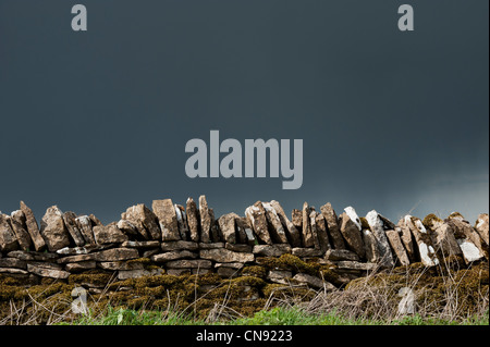 Stormy rain clouds over old dry stone wall in the English countryside Stock Photo