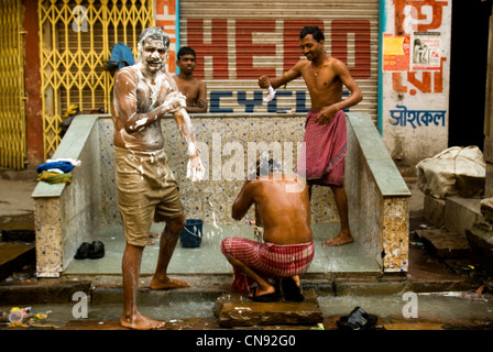 Men taking bath on the street of Kolkata  , India Stock Photo