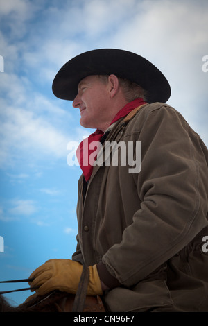 Cowboy in saddle with yellow leather gloves.  Captured on ranch in northeastern Wyoming. Stock Photo