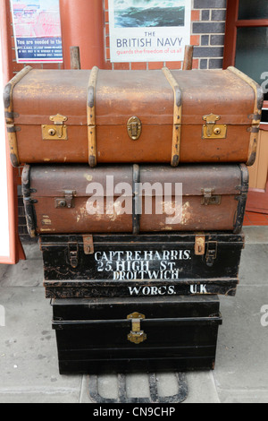 Historic 1930s period left luggage and military trunks with nationalist posters on display at Severn Valley railway station. Stock Photo