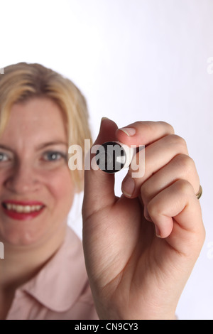 Close up of a smiling lady holding a marker pen towards camera Stock Photo