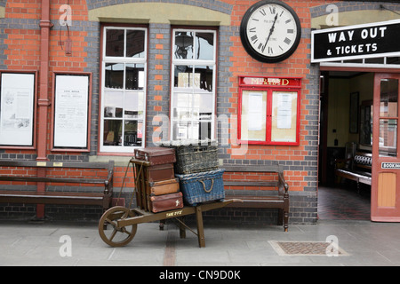 Severn Valley steam railway station precinct at Kidderminster with 1930s period luggage on tradtiional station wheelbarrow. Stock Photo