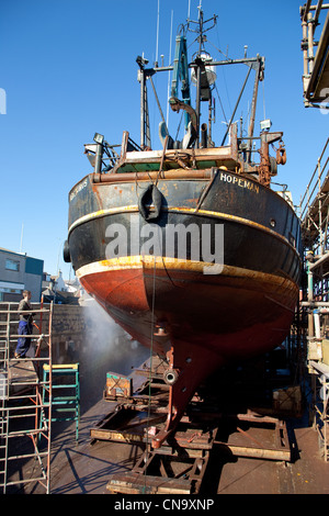 Spay cleaning of Trawler Hull on the slipways,in repair yards at Peterhead Harbour Scotland UK Stock Photo