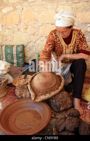 Berber woman extracting oil from Argan nut kernals at the Assous Argane oil co-operative, Souss Valley, Morocco, north Africa Stock Photo