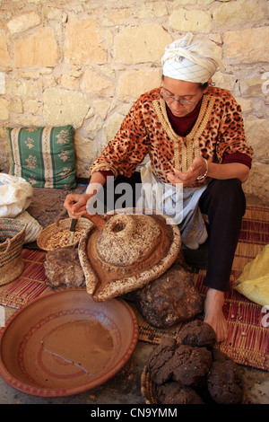 Berber woman extracting oil from Argan nut kernals at Assous Argan oil co-operative, Souss Valley,  Morocco, north Africa Stock Photo