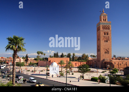 The minaret of Koutoubia mosque soars above Avenue Mohammed V against snow cap High Atlas mountains, Marrakech, Morocco, Africa Stock Photo