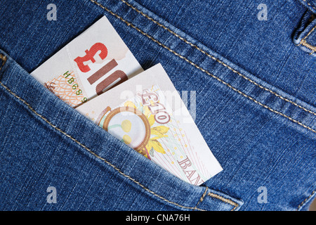 UK money sterling ten pound note GBP cash in a back pocket of a pair of blue denim jeans to illustrate a lifestyle concept. England Britain Stock Photo