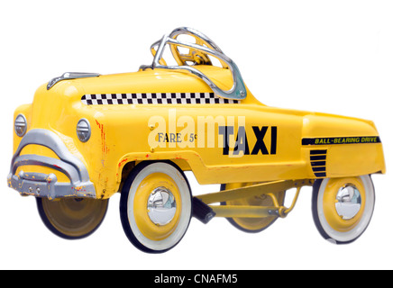 Pareidolia sad faced car with some dents and paint marks. Kid's size small version of a vintage Yellow New York Taxi Cab. Old push bike pedal car. Stock Photo
