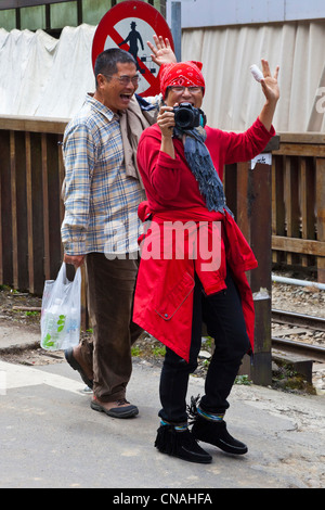 Chinese man and woman in red coat and hat taking photograph, Alishan, Taiwan. JMH5910 Stock Photo