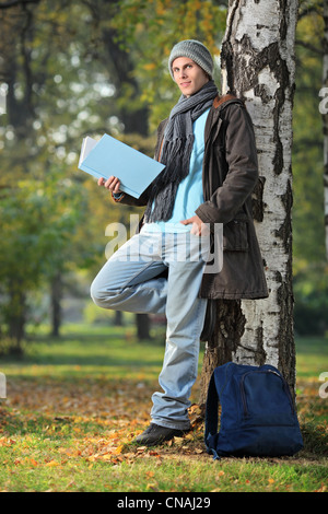 Young man reading a book in the city park