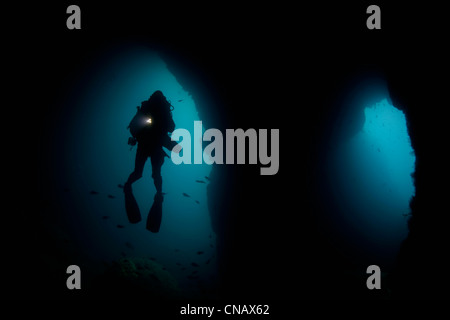 Diver swimming in underwater cave Stock Photo