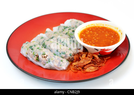 Vietnamese rice noodle rolls with a filling of pork sliced and vegetable , fried onion served with spicy sauce Stock Photo