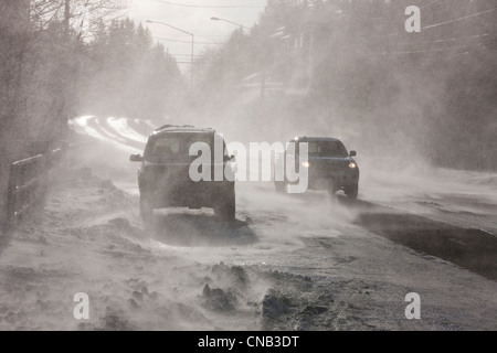 Vehicles drive on Douglas Roadway obscured by 70 mph blowing wind and snow, Juneau, Southeast Alaska, Winter Stock Photo