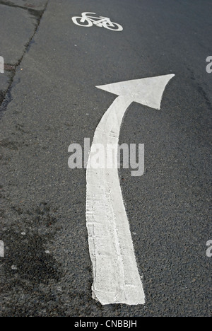 british road marking in form of right curving arrow, with cycle marking ahead Stock Photo