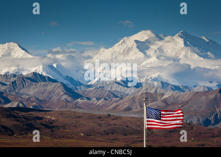 An American flag flys in the wind at Eielson Visitor Center with Mt. Mckinley in the background,  Denali National Park, Alaska Stock Photo