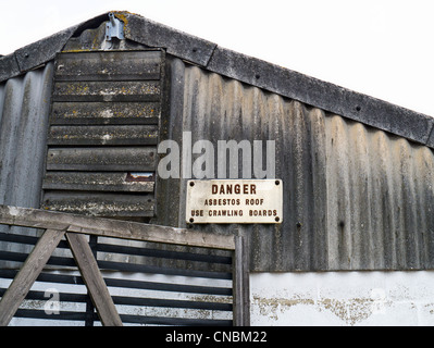 Danger Sign on an Industrial Building with Corrugated Asbestos Roof and Wall Stock Photo