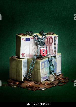 Bundles of Euro banknotes secured with chains and a lock Stock Photo