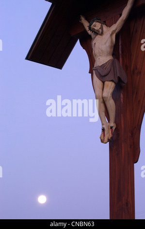 Figure of crucified Jesus Christ and a full moon Stock Photo