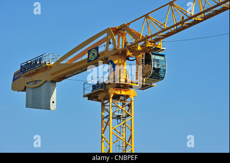 Yellow construction crane on building site showing cabin and counterweight Stock Photo