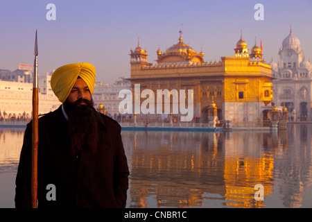 India, Punjab, Amritsar, Golden Temple and Sikh guard at sunrise Stock Photo