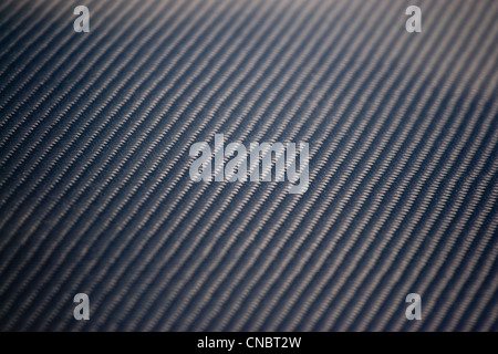 A closeup of real carbon fiber material. This makes an excellent texture or background. Shallow depth of field. Stock Photo