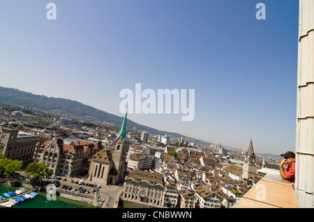 Horizontal wide angle aerial of a tourist enjoying the view across the historical centre of Zürich on a bright sunny day. Stock Photo