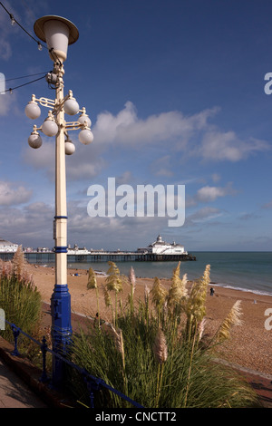 Ornate street lamp, beach and Eastbourne pier seen from the promenade, Eastbourne, East Sussex, England, UK Stock Photo