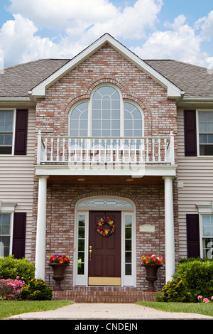 The front entrance of a large custom built luxury home in a residential neighborhood. Stock Photo