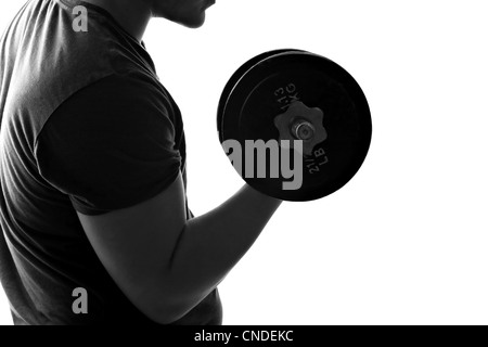 Back lit silhouette of a young man lifting weights in black and white. Stock Photo