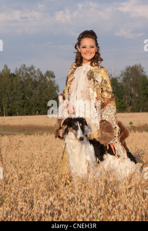 Woman in clothes of 18 centuries outdoors hold borzoi dog Stock Photo