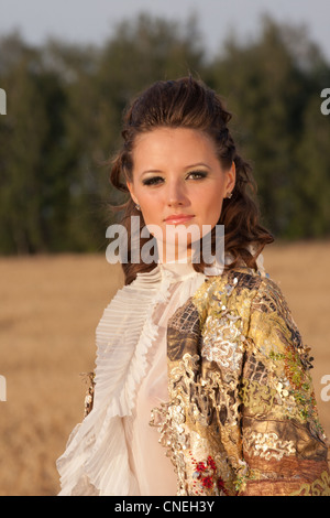 Portrait of young woman in clothes of 18 centuries outdoors. On sky background Stock Photo