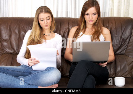 Two beautiful young females studying and using laptop Stock Photo