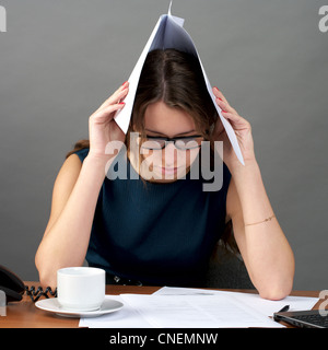 Beautiful young employer looking at documents with troubled expression Stock Photo