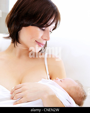 Happy mother holding sleeping baby, healthy family concept