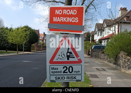 no road markings and 20mph speed limit loose chippings signs beside newly resurfaced road Stock Photo