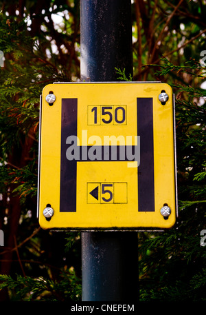 A fire hydrant location sign on a street lamp post in a residential ...