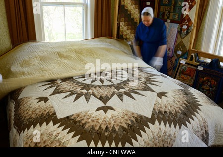 Mennonite seamstress displaying handmade quilts in her bedroom near St Jacobs Ontario Stock Photo