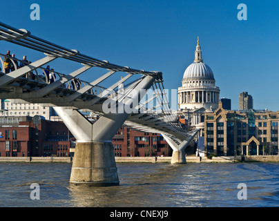 Millennium Bridge with visitors in crisp clear sunshine with St Paul's Cathedral at the focal point City of London UK Stock Photo