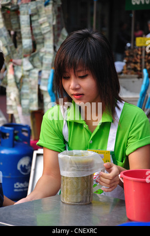 Young woman working in street seafood stall, Yaowarat Road (Chinatown), Samphanthawong District, Bangkok, Thailand Stock Photo