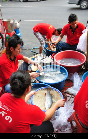 Staff preparing fish at street seafood stall, Yaowarat Road (Chinatown), Samphanthawong District, Bangkok, Thailand Stock Photo