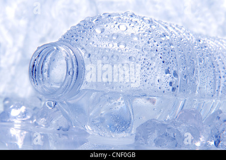 Closeup of a water bottle laying on its side with droplets and drip coming out of the opening. Stock Photo