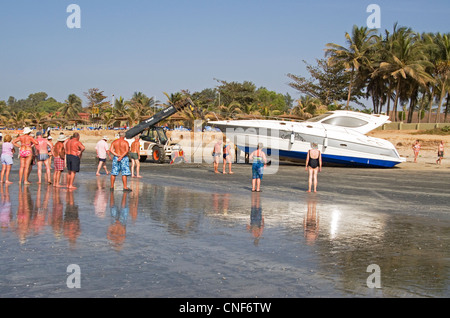 A crowd gathers as attempts are made to move a large yacht grounded on Kololi beach Gambia west Africa Stock Photo