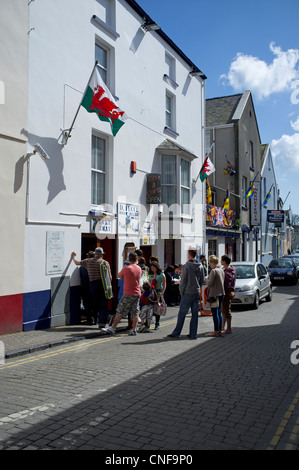 Customers stand in line for take away fish & chips Tenby town centre Pembrokeshire South Wales UK Stock Photo