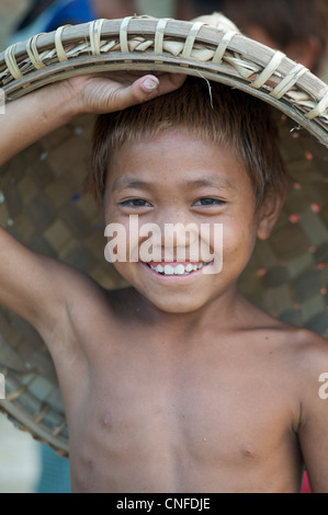 Burmese child with rattan basket on head working on the waterfront, Mandalay, Burma. Myanmar Stock Photo
