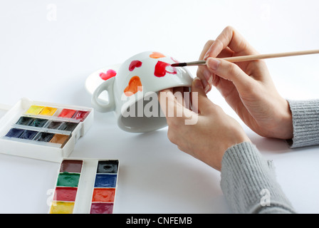 Hands are depicting hearts on the cup on Valentine's Day. A gift with love Stock Photo