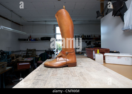 A leather riding boot in a shoe makers workshop. Stock Photo