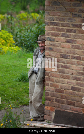A senior man leaning against a wall Stock Photo